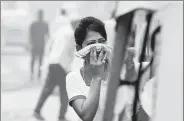  ?? RAJ K RAJ / HINDUSTAN TIMES VIA GETTY IMAGES ?? A girl covers her nose to protect herself from air pollution onTuesday in New Delhi.