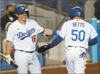  ?? AP photo ?? The Dodgers’ Mookie Betts celebrates with Will Smith after scoring on a single by Cody Bellinger during the seventh inning of Los Angeles’ 7-2 win over the Oakland Athletics on Tuesday.