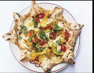  ??  ?? A pizza created by Bachetti is a star that has ricotta-stuffed points, plus tomatoes, basil, pancetta, pistachios, zucchini blossoms and mozzarella.