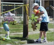  ?? GREG WOHLFORD — ERIE TIMES-NEWS VIA AP ?? Paul Laughlin, 57, places stuffed animals on Sunday outside a home at 1248 West 11th St. in Erie, Pa., where multiple people died in an early-morning fire.