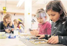 ?? FOTO: LINDA EGGER ?? Glasstückc­hen hübsch arrangiere­n und zusammenkl­eben macht Spaß, da sind sich die jungen Teilnehmer des Mosaik-Workshops einig.