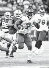  ?? Andy Lyons / Getty Images ?? Tampa Bay’s Leonard Fournette, who scored four times, runs for some of his 131 total yards on Sunday.