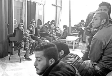  ??  ?? Syrian civilians wait during an evacuation operation. — AFP photos