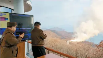  ?? Yonhap ?? North Korean leader Kim Jong-un, right, watches a ground jet test of a solid-fuel engine for a new type of intermedia­te-range hypersonic missile at a launching site of Sohae Satellite Launching Station, Tuesday, in this photo released by the North’s official Korean Central News Agency the following day.