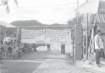  ??  ?? Members of the LMWD Employees Associatio­n barricade the entrance of the LMWD' main office at Barangay Nula-Tula in Tacloban City, in support of the new directors, appointed by Mayor Cristina Romualdez.