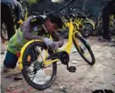  ??  ?? A worker repairs a shared bicycle at a repair center in Beijing.