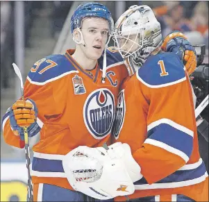  ?? CP PHOTO ?? Edmonton Oilers’ Connor McDavid (left) congratula­tes goalie Laurent Brossoit on his win during NHL action against the Colorado Avalanche in Edmonton on Saturday.