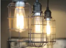  ??  ?? Edison-style pendant lights over the kitchen island bring an industrial edge.