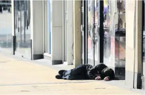  ??  ?? A homeless person sleeps on the street in Bristol city centre