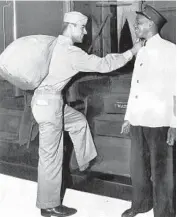  ?? CHICAGO TRIBUNE HISTORICAL PHOTO ?? Pvt. Ramirez, left, is welcomed by J. L. Fischer, Pullman porter, as Ramirez prepares to board a Pullman car on the Pennsylvan­ia lines at Union Station for a trip south in 1945.