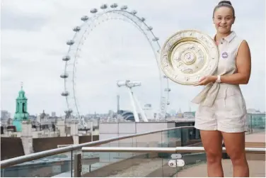  ?? Reuters ?? ↑
Australia’s Ashleigh Barty poses with the Wimbledon trophy on the balcony of the Park Plaza in front of the London Eye on Sunday.