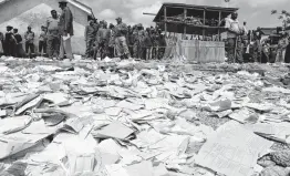  ?? Khalil Senosi / Associated Press ?? School papers lie on the ground as people gather at the site of the Precious Talent Top School building after it collapsed in Nairobi, Kenya, on Monday.