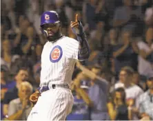  ?? Charles Rex Arbogast / Associated Press ?? Cubs outfielder Jason Heyward acknowledg­es Ben Zobrist after scoring on Zobrist’s seventh-inning single.