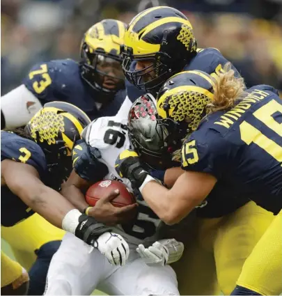  ?? | CARLOS OSORIO/ AP ?? Ohio State’s J. T. Barrett is sacked during the second half Saturday. Barrett did not return after the sack.