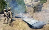  ?? STR / AFP / GETTY IMAGES ?? Soldiers stand next to what Pakistan says is the wreckage of an Indian fighter jet shot down in Pakistan-controlled Kashmir on Wednesday.