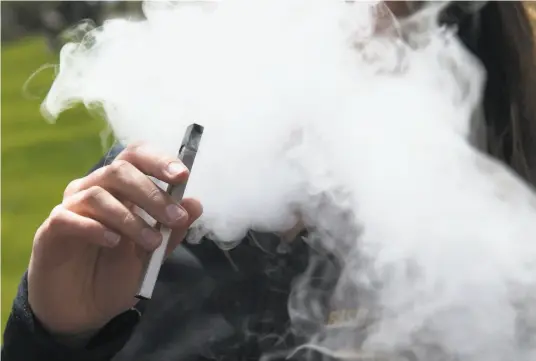  ?? Jessica Christian / The Chronicle 2018 ?? A high school student is shrouded in smoke from vaping a Juul ecigarette. Vaping and smoking pot or tobacco increases COVID19 risk, doctors warn.