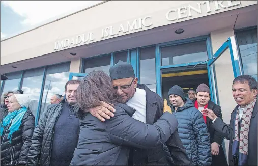 ?? CP PHOTO ?? Haroon Sheriff President of Imdadul Islamic Centre (centre right) hugs Rabbi Yael Splansky at friday prayers as Members of the Holy Blossom Synagogue and the Fair Lawn United Church form a peace ring around the Toronto mosque on Friday, February 3,...