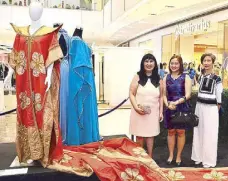  ??  ?? SM SVP for marketing Millie Dizon (left) with Metrobank Foundation’s Lalaine Calicdan (center) and Jesthela Lizardo (right) admire the costumes from the Metropolit­an Theater performanc­e, including the magnificen­t orange outfit with a train from The...