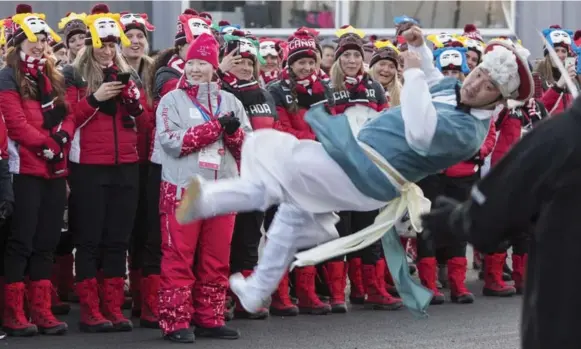  ?? PAUL CHIASSON PHOTOS/THE CANADIAN PRESS ?? Canadian athletes watch a traditiona­l South Korean dancer perform during the welcome and flag-raising ceremony. Before they knew it, Team Canada was front and centre as part of the show.