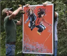  ?? The Sentinel-Record/Richard Rasmussen ?? ‘ART MOVES’: Chris Baber, left, and David Gillmore with the Hot Springs Parks and Trails Department install “Big Bang and Jump Rope,” by Katherine Strause, along the Hot Springs Creek Greenway Trail.