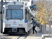  ??  ?? A passenger pushes a button to open the door prior to boarding a southbound H- Line on RTD light rail at the Colfax at Auraria station on Wednesday.