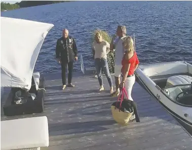  ??  ?? A security video shows Linda O'Leary, in blue jeans and white top, wife of celebrity investor Kevin O'Leary, in black shirt, with the speedboat before they left for a neighbour's cottage on the evening of a fatal boat crash.