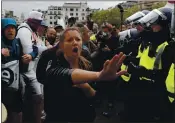  ?? FRANK AUGSTEIN — THE ASSOCIATED PRESS ?? Police face protesters Saturday at a rally at Trafalgar Square in London to oppose COVID-19 restrictio­ns.