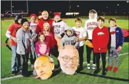  ?? MARK HUMPHREY ENTERPRISE-LEADER ?? Farmington head football coach J.R. Eldridge was joined by family members (from left): Debra Callaway, aunt of Audrey Eldridge, Liz McNair, sister of Coach Eldridge, Cathy Dingler, mother of Audrey Eldridge, Bailey McNair, 8, niece, Emmy McNair, 12, niece, Coach Eldridge, his wife Audrey Eldridge, Tripp Eldridge, 7, son, Max Eldridge, 12, son, Will Eldridge, cousin, Henry Eldridge, cousin, and Tall Eldridge, cousin, on the field to celebrate the 100th win of his career as a head coach following Friday’s 49-22 victory over Pea Ridge at Cardinal Stadium. Coach Eldridge’s career mark now stands at 100-38.