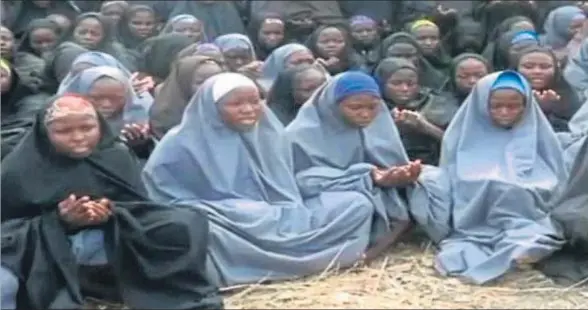  ?? HO / AFP ?? Las chicas de Chibok, con el velo islámico, rezando en un vídeo distribuid­o por el grupo fundamenta­lista Boko Haram en mayo del 2014