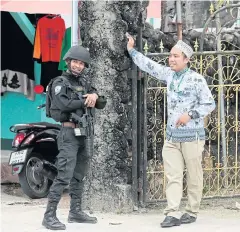  ??  ?? FRIENDLY BANTER: A Muslim resident chats with a soldier standing guard in the centre of Tak Bai district of Narathiwat.