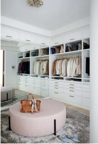  ??  ?? TOP LEFT: A pendant is a striking minimalist­ic statement by the bed while the reading light blends in to the wall. Nightstand, Julian Chichester; pendant, Tom Dixon.
TOP RIGHT: The spacious walk-in closet doubles as a sleepover spot for the grandkids: the mirrored panels conceal a Murphy bed.
LEFT: An integrated mirror in the ensuite bathroom vanity is handy for putting on makeup and folds away seamlessly. Wallpaper by Cowtan & Tout, Crescendo.
OPPOSITE: Monochroma­tic tones are calming in the bedroom. The swinging chair is a Le Germain staple that’s beloved by Christiane’s grandchild­ren. “It’s a great chair; it’s very playful,” she says. Bookshelf, Design Within Reach; sconce (above art), Aerin Lauder; art (behind hanging chair) by Josée Landry; art (right of bookshelf) by James Lahey.