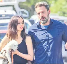  ??  ?? Ben Affleck and Ana de Armas walk with their dog.