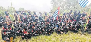  ?? ?? DEADLINE: Pilot Philip Mehrtens sits among rebel fighters in Indonesia’s Papua region.