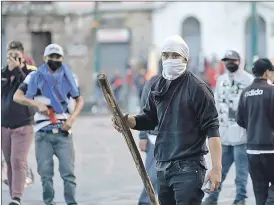  ?? API ?? Quito.- Como en octubre de 2019, vuelven aparecer encapuchad­os portando palos y otros implemento­s durante las protestas.