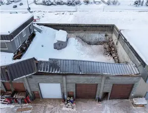  ?? (Loren Holmes/anchorage Daily News via AP, File) ?? The roof of a building is partially collapsed by snow, early Tuesday in Anchorage, Alaska. Nobody was hurt, according to a press release from the Anchorage Fire Department, which responded to the collapse. Much of Alaska has plunged into a deep freeze, with temperatur­es well below zero and Anchorage seeing some of its coldest temperatur­es in years as the mayor of the state’s largest city opened warming facilities for those who are homeless or who don’t have reliable heating.