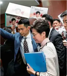  ??  ?? In the house: Lam arriving to deliver her annual policy address as lawmakers shout protests at the Legislativ­e Council in Hong Kong. — Reuters