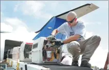  ?? KAREN WARREN / ASSOCIATED PRESS ?? Pilot Derek Harbaugh helps on Monday to unload a pet dog from a plane ahead of Hurricane Sally’s expected arrival in Houston, Texas.