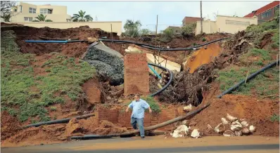  ??  ?? Councillor Andre Beetge visits the site below Mayville Terrace, eManzimtot­i, where part of the boundary wall of the Lagoon Point complex has caved in.