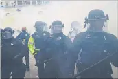  ?? JOHN MINCHILLO — THE ASSOCIATED PRESS ?? Police form a line to try to prevent rioters from storming the Capitol in Washington on Jan. 6.