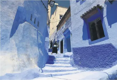  ?? Pictures: AFP ?? FEELING BLUE. A woman walks along a small alley in the northweste­rn Moroccan city of Chefchaoue­n, in the Rif mountains.