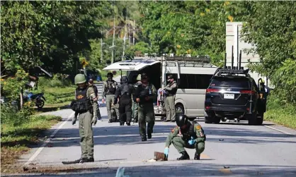  ?? Photograph: Tuwaedaniy­a Meringing/AFP via Getty Images ?? Members of a bomb squad inspect the site of an attack by suspected Muslim militants in Yala province that killed at least 15 people.