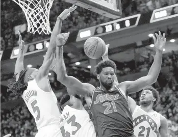  ?? NATHAN DENETTE / AP ?? 76ers center Joel Embiid (21) can’t come up with the offensive rebound against Raptors forward Thaddeus Young (21) and teammates Precious Achiuwa and Pascal Siakam on Saturday in Toronto during the second half of Game 4 of the teams’ firstround Eastern Conference playoff series.