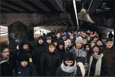  ?? ?? Ukrainians crowd under a destroyed bridge March 8 as they try to flee fighting by crossing the Irpin River on the outskirts of
Kyiv.