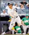  ??  ?? New York Yankees’ Giancarlo Stanton hits an RBI single off Oakland Athletics relief pitcher Yusmeiro Petit to tie the score in the seventh inning of a baseball game, on June 19, in New York. (AP)