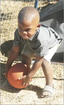 ?? Brodie Johnson • Times-Herald ?? Children in area daycare centers spent the morning enjoying the sunlight and playing different games together. Kasen Kelly, 2, picks up a ball to play with on the playground at Teach and Tend.