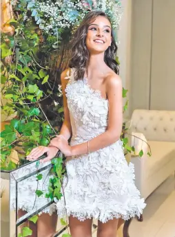  ??  ?? Elegante lució la quinceañer­a con un vestido de un solo hombro con flores 3D en tono blanco y un maquillaje de estilo romántico.