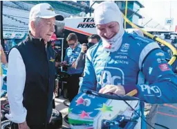  ?? DARRON CUMMINGS/AP ?? Roger Penske, left, talks with Josef Newgarden before a practice session Friday for the IndyCar race at Indianapol­is Motor Speedway in Indianapol­is.