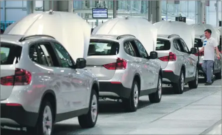  ?? NELSON CHING / BLOOMBERG ?? BMW X1 compact sport utility vehicles move along an assembly line at BMW Brilliance Automotive’s Tiexi plant in Shenyang, Liaoning province.
