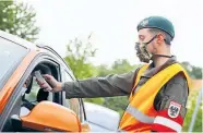  ??  ?? Milizsolda­t an der Grenze bei Bad Radkersbur­g beim Fiebermess­en. Viele Einberufen­e machten jedoch ihre Unabkömmli­chkeit beim Arbeitgebe­r geltend.