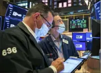  ?? Associated Press ?? Traders work on the floor of the New York Stock Exchange on Wednesday. Stocks were mostly higher in afternoon trading.